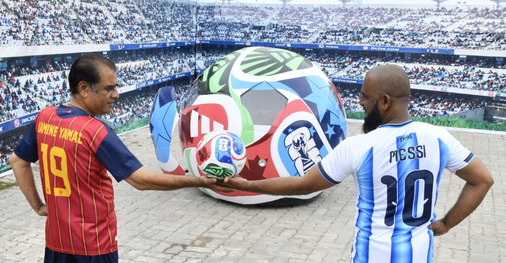 Onlookers watch as the FIFA World Cup-themed Soccer Ball Car drives along the road after its unveiling at Sudha Cars Museum, Bahadurpura Cross Roads, Hyderabad, on Saturday.