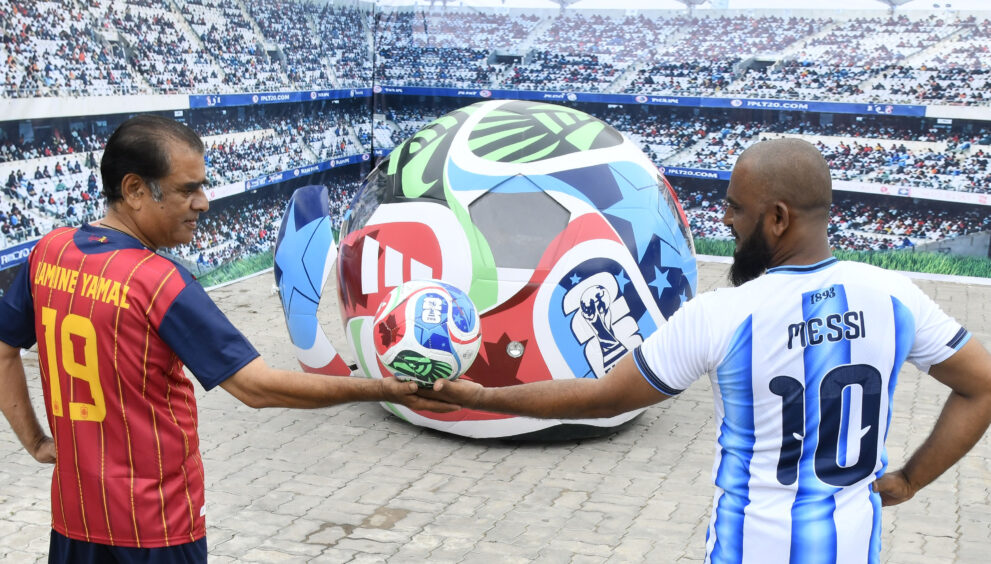 Onlookers watch as the FIFA World Cup-themed Soccer Ball Car drives along the road after its unveiling at Sudha Cars Museum, Bahadurpura Cross Roads, Hyderabad, on Saturday.